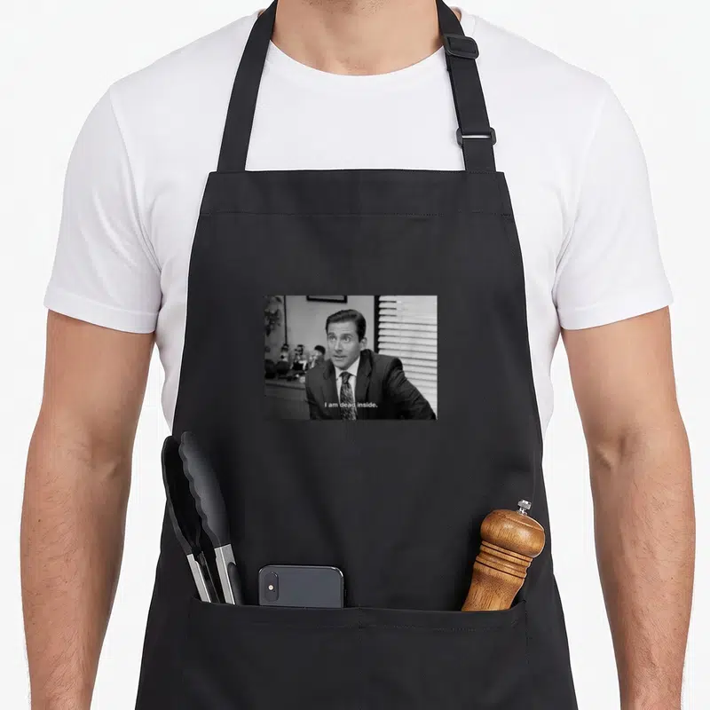 Tablier de cuisine noir avec une illustration en noir et blanc représentant un homme en costume et le texte I am dead inside.