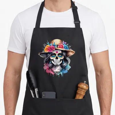 Tablier de cuisine noir avec une illustration de crâne femelle coiffé de roses et d'un chapeau de paille.