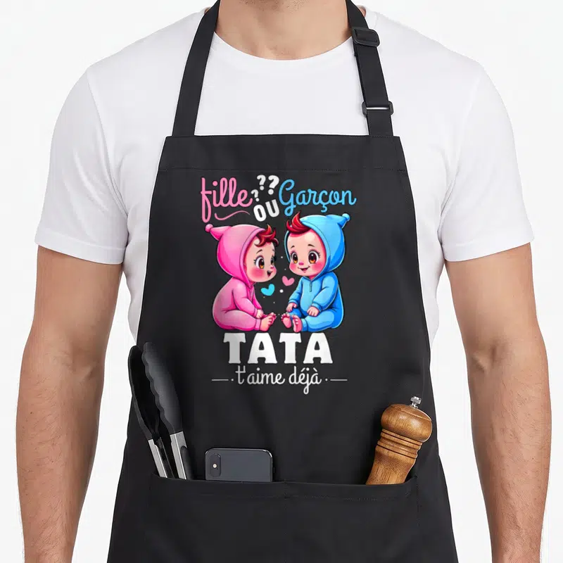 Tablier de cuisine noir avec illustration Tata t'aime déjà fille ou garçon et deux bébés roses et bleus.