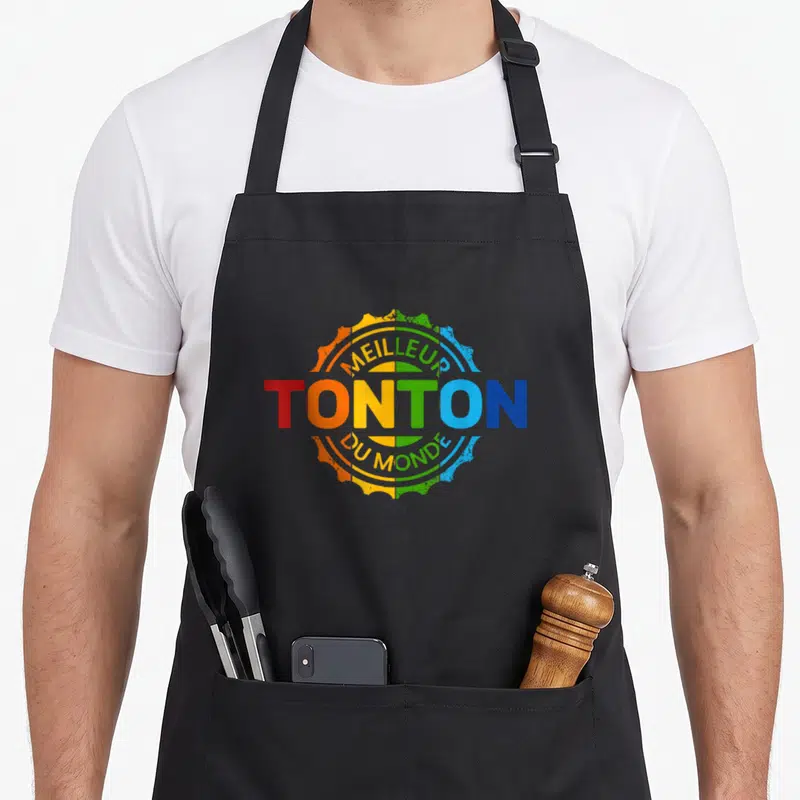 Tablier de cuisine noir avec un logo multicolore affichant Meilleur Tonton du Monde.