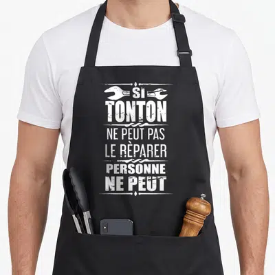 Tablier de cuisine noir avec inscription blanche et deux clés anglaises stylisées en haut du motif.
