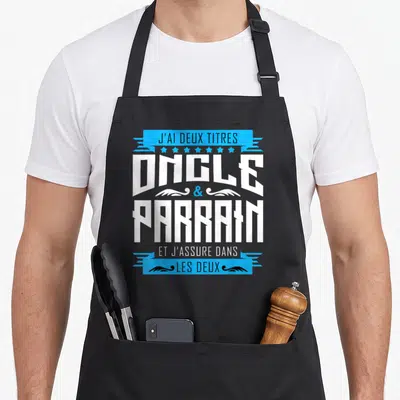 Tablier de cuisine noir avec typographie blanche et bleue proclamant les titres d'oncle et parrain.