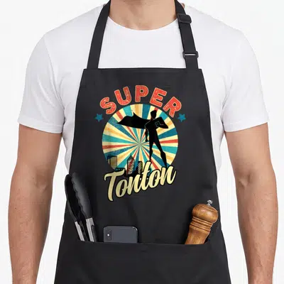 Tablier de cuisine noir avec illustration super tonton silhouette cape ville rayons couleurs