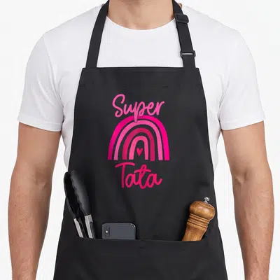 Tablier de cuisine noir avec un arc-en-ciel rose vif et le texte Super Tata en lettres cursives roses.