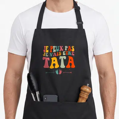 Tablier de cuisine noir avec inscription colorée Je peux pas je vais être tata et des petits pieds.