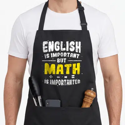 Tablier de cuisine noir avec inscription blanche et jaune sur fond gris uni