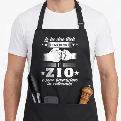 Tablier de cuisine noir avec illustration de poings et texte Lo ho due titoli Padrino Zio en blanc.