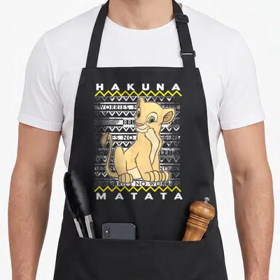 Tablier de cuisine noir avec Nala et le texte Hakuna Matata sur fond de motifs Noël géométriques.
