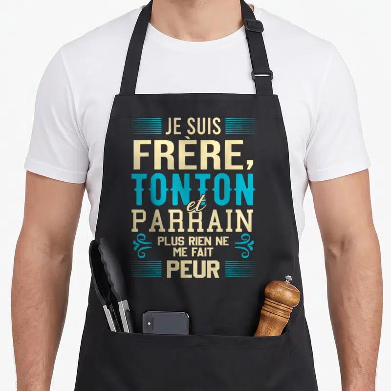 Tablier de cuisine noir avec typographie Je suis frère tonton et parrain plus rien ne me fait peur en beige et bleu cyan.
