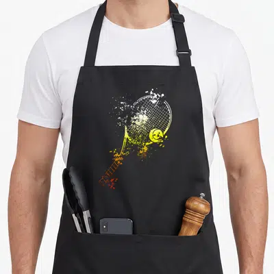Tablier de cuisine noir avec illustration stylisée d'une raquette de tennis et d'une balle jaune aux effets de peinture.