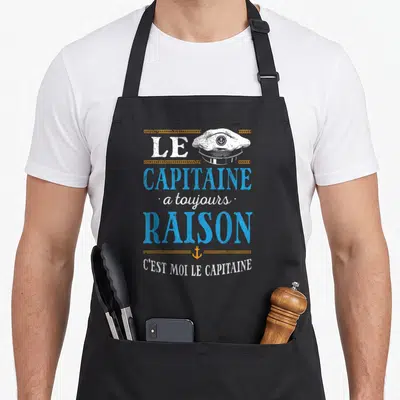 Tablier de cuisine noir avec inscription Le capitaine a toujours raison et illustration de casquette de marin.