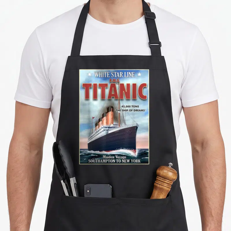 Tablier de cuisine noir avec illustration vintage du R.M.S. Titanic et l'inscription White Star Line en lettres rouges sur fond de mer.