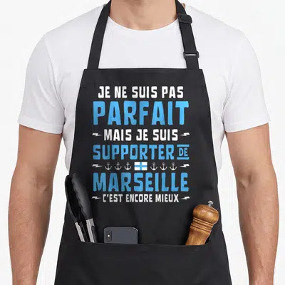 Tablier de cuisine noir avec inscription Je ne suis pas parfait mais je suis supporter de Marseille en bleu et blanc.