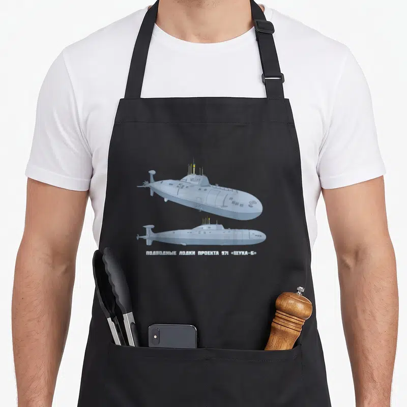 Tablier de cuisine noir avec diagramme technique d'un sous-marin gris et inscriptions en alphabet cyrillique.