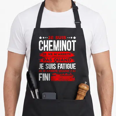 Tablier de cuisine noir avec inscription Je Suis Cheminot et illustration de train rouge vintage en bas de page.