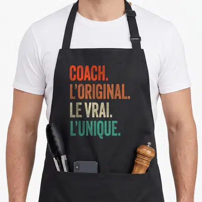 Tablier de cuisine noir avec inscription Coach l'original le vrai l'unique en lettres orange beige et vert turquoise.