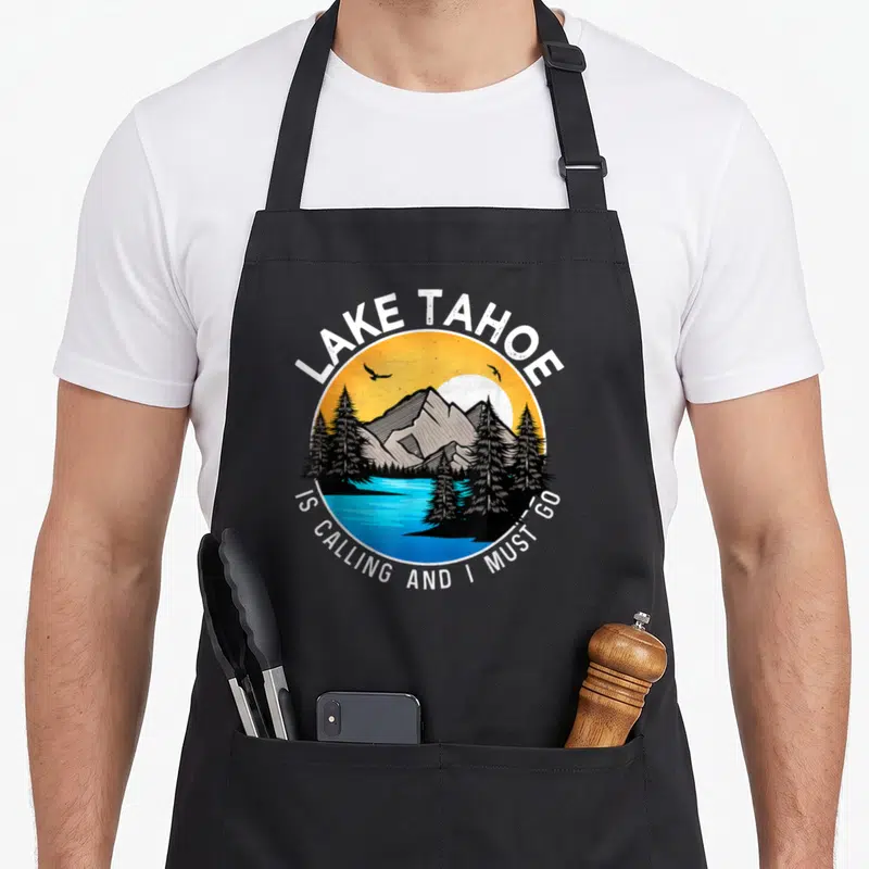 Tablier de cuisine noir avec illustration circulaire Lake Tahoe is calling and I must go montrant montagnes et lac.