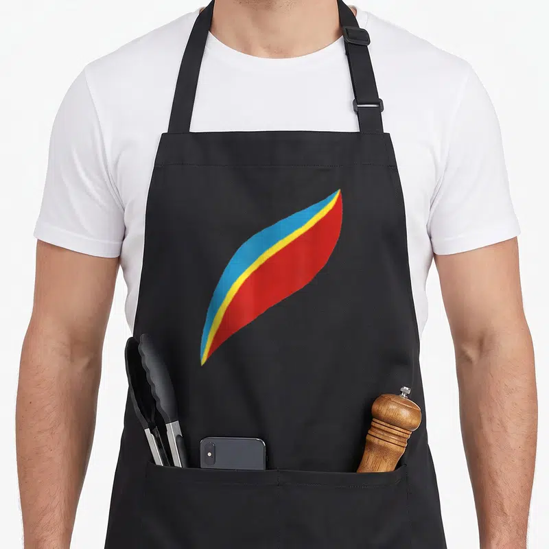 Tablier de cuisine noir avec une forme stylisée rouge, jaune et bleue imprimée au centre.