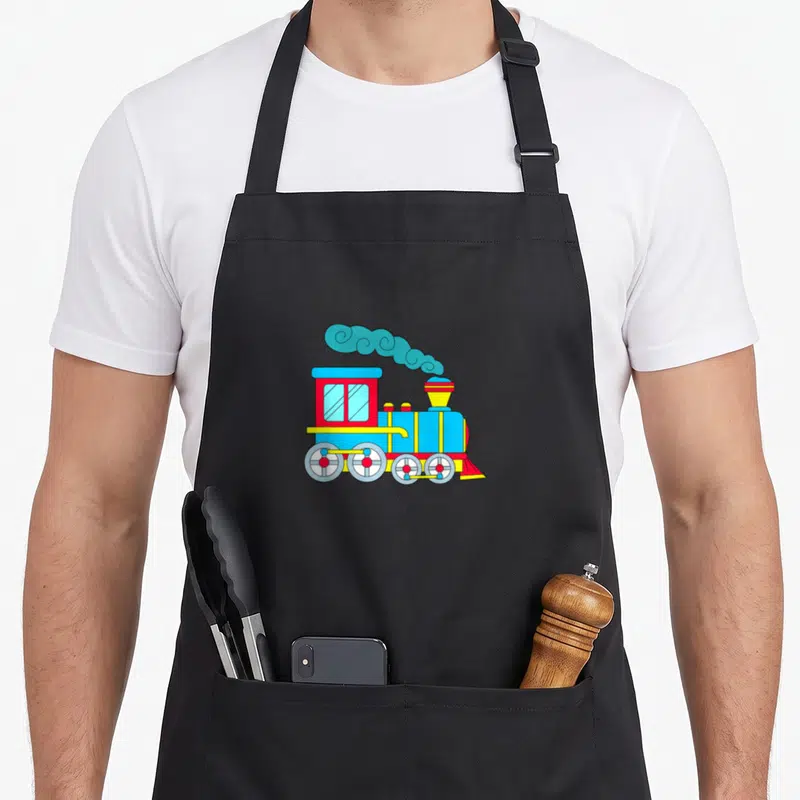 Tablier de cuisine noir avec une illustration de train à vapeur multicolore et fumée bleue stylisée.