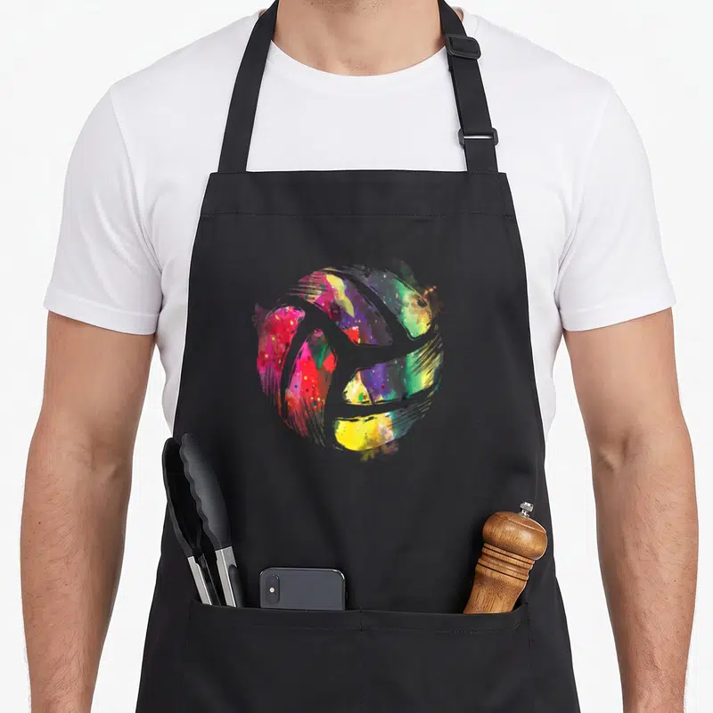 Tablier de cuisine noir avec illustration circulaire abstraite aux couleurs vives évoquant un sport d'entraînement de volleyball d'équipe
