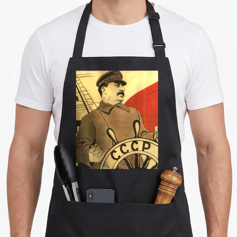 Tablier de cuisine noir avec une illustration vintage de Staline capitaine tenant la barre du CCCP.