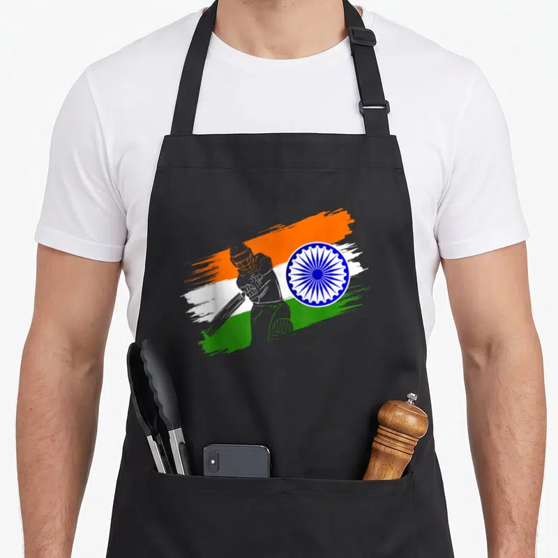 Tablier de cuisine noir avec frappeur de cricket et drapeau indien stylisé en touches de peinture.