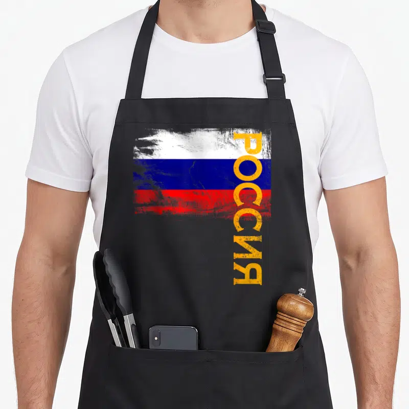 Tablier de cuisine noir avec drapeau russe stylisé et texte vertical Rossia en orange sur fond gris.