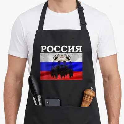 Tablier de cuisine noir avec un ours russe superposé au drapeau et le mot YA en lettres blanches.