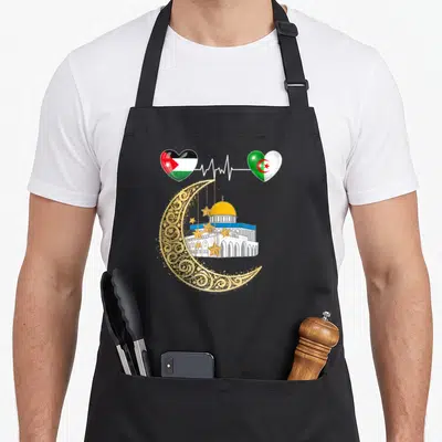 Tablier de cuisine noir avec croissant doré, mosquée d'Aqsa et cœurs aux drapeaux de Jordanie et Algérie connectés par une ligne cardiographique.