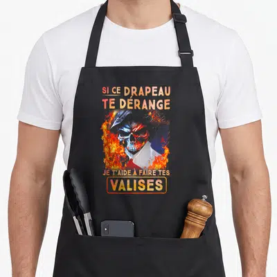 Tablier de cuisine noir avec un crâne enflammé et un drapeau aux couleurs vives au centre du motif.