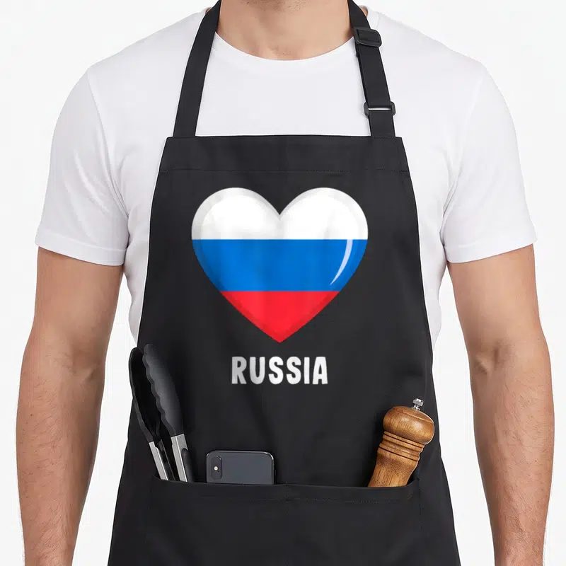 Tablier de cuisine noir avec un grand cœur tricolore blanc bleu rouge et l'inscription RUSSIA en bas.