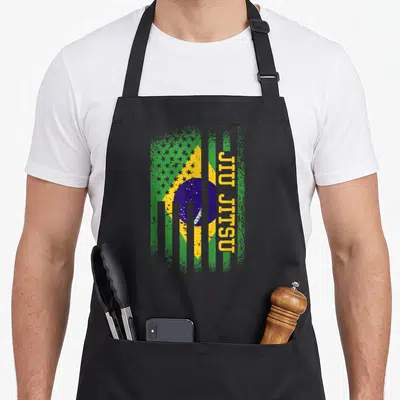 Tablier de cuisine noir avec drapeau brésilien et américain du Jiu Jitsu en vert jaune bleu et texte vertical jaune.