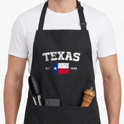 Tablier de cuisine noir avec inscription TEXAS et drapeau EST 1845 aux couleurs bleu blanc rouge.