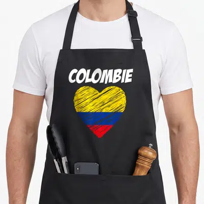 Tablier de cuisine noir avec le mot COLOMBIE au-dessus d'un cœur aux couleurs du drapeau colombien dessiné au trait.