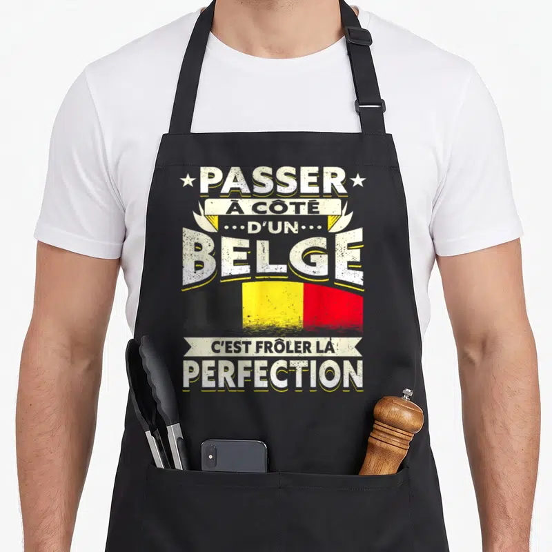 Tablier de cuisine noir avec inscription blanche et drapeau belge aux couleurs noires jaunes et rouges.