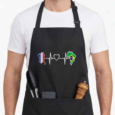 Tablier de cuisine noir avec une carte de France et du Brésil reliées par un rythme cardiaque blanc.