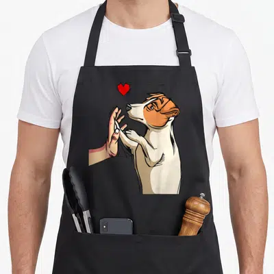 Tablier de cuisine noir avec illustration d'un Jack Russell Terrier tendant sa patte à une main humaine sous un cœur rouge vif.