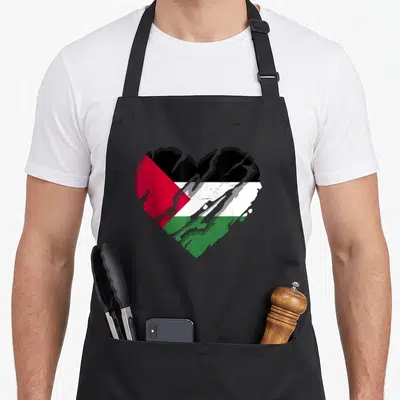 Tablier de cuisine noir avec un grand cœur aux couleurs du drapeau Palestine en style graffiti texturé.
