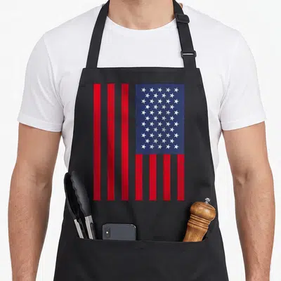 Tablier de cuisine noir avec un drapeau américain vintage composé d'étoiles blanches et de rayures rouges distinctes.