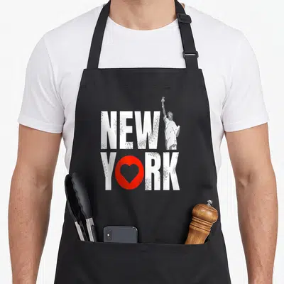 Tablier de cuisine noir avec l'inscription New York en blanc, un cœur rouge et une silhouette de la Statue de la Liberté.