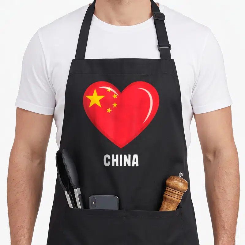 Tablier de cuisine noir avec un cœur rouge stylisé aux étoiles jaunes et l'inscription CHINA en blanc.