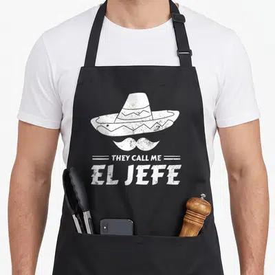Tablier de cuisine noir avec illustration blanche d'un sombrero, d'une moustache et du texte They Call Me El Jefe.