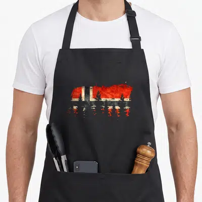 Tablier de cuisine noir avec drapeau Norvège rouge et bleu en forme de bœuf au-dessus de sapins noirs.