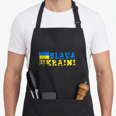 Tablier de cuisine noir avec drapeau ukrainien et texte Slava Ukraini en bleu et jaune texturé.