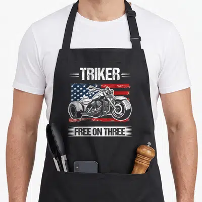 Tablier de cuisine noir avec illustration de trike sur fond de drapeau américain et texte Triker Free on Three en blanc.