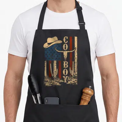 Tablier de cuisine noir avec illustration cowboy western paysager désertique et drapeau américain délavé