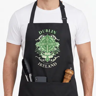 Tablier de cuisine noir avec une croix celtique verte et des inscriptions Dublin Irlande Republic of Ireland en blanc et vert.