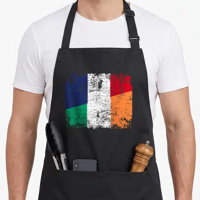 Tablier de cuisine noir avec un drapeau de l'amitié fusionnant les teintes irlandaises et françaises en texture vieillie.