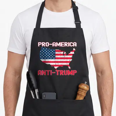 Tablier de cuisine noir avec une carte des USA en drapeau et les textes PRO-AMERICA ANTI-TRUMP en rouge et blanc.