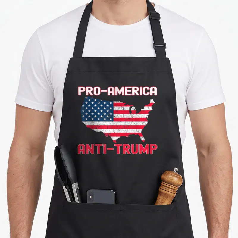 Tablier de cuisine noir avec une carte des USA en drapeau et les textes PRO-AMERICA ANTI-TRUMP en rouge et blanc.